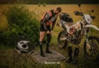 Motocyklista off-roadowy nakłada ortezy kolanowe