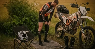 Motocyklista off-roadowy nakłada ortezy kolanowe